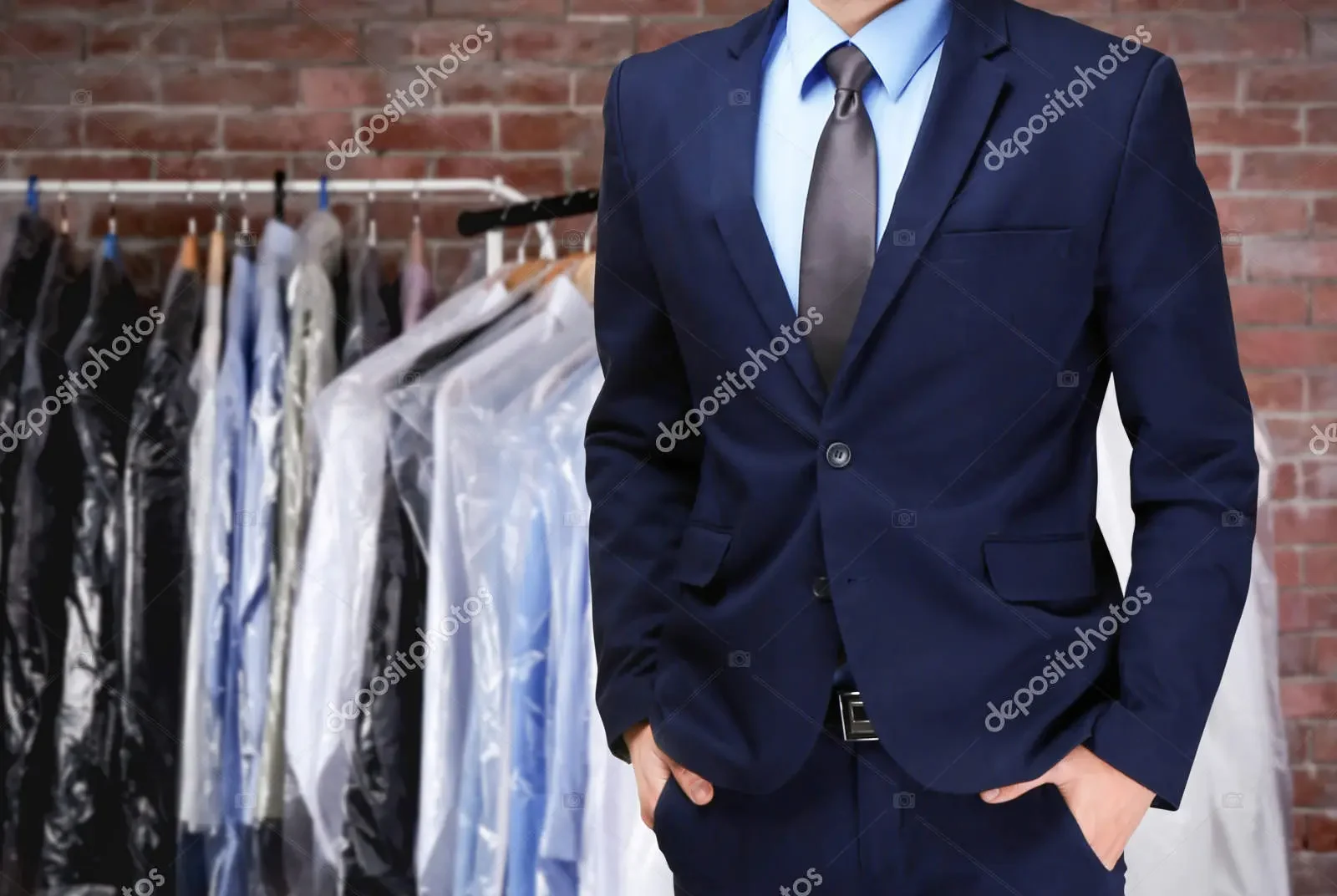 man in suit in front of dry cleaning rack